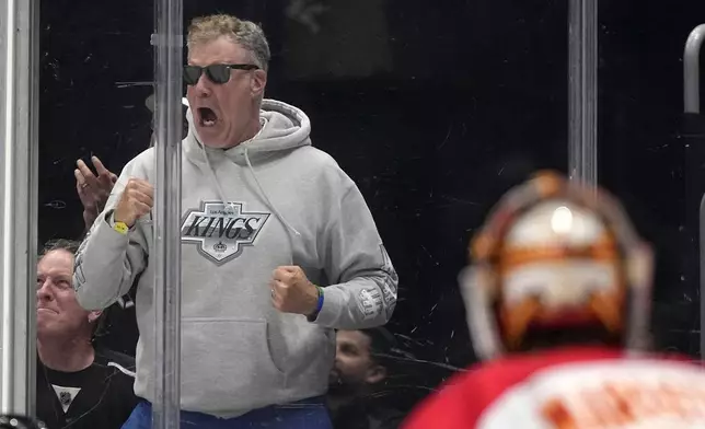 Actor Will Ferrell, left, cheers as Calgary Flames goaltender Jacob Markstrom watches during the second period of an NHL hockey game between the Los Angeles Kings and the Flames Thursday, April 11, 2024, in Los Angeles. (AP Photo/Mark J. Terrill)