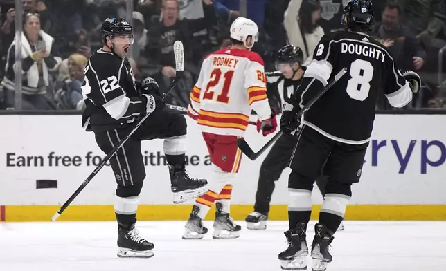 Los Angeles Kings left wing Kevin Fiala, left, celebrates his goal with defenseman Drew Doughty, right, as Calgary Flames center Kevin Rooney skates away during the first period of an NHL hockey game Thursday, April 11, 2024, in Los Angeles. (AP Photo/Mark J. Terrill)
