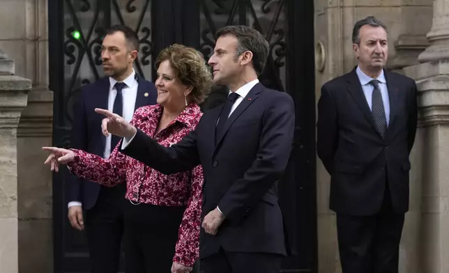 French President Emmanuel Macron and British ambassador to France Menna Rawlings gesture outside the Elysee Palace, Monday, April 8, 2024 in Paris. Sixteen soldiers from No 7 Company Coldstream Guards and 32 members of the Gendarmerie Garde Republicaine mount guard at the Elysee palace as British troops join French guards in a special ceremony at the Elysee Palace to celebrate 120 years of "entente cordiale" between the longtime rival powers. (AP Photo/Thibault Camus, Pool)