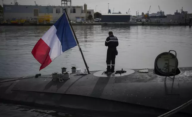 A sailor prepares a French Rubis-class submarine at the Toulon naval base in southern France, Monday, April 15, 2024. The nuclear powered submarine will be guarding France's Charles de Gaulle aircraft carrier during training exercises dubbed Neptune Strike in the Mediterranean with the 32-nation NATO military alliance. (AP Photo/Daniel Cole)