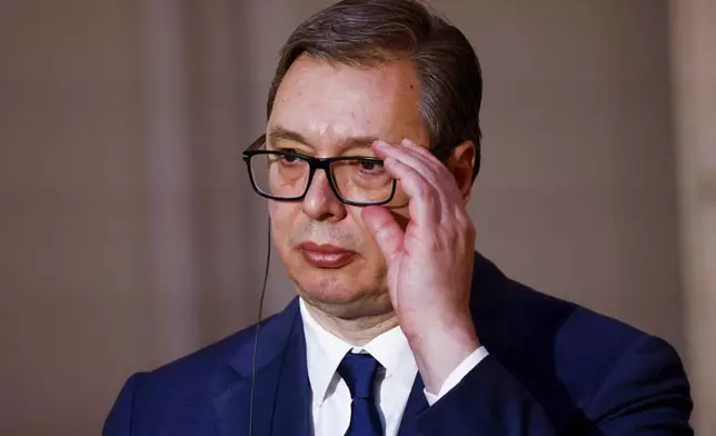 Serbian President Aleksandar Vucic adjusts his glasses during a joint statement with French President Emmanuel Macron , before a working dinner at the Elysee Palace in Paris, Monday, April 8, 2024. (Sarah Meyssonnier/Pool via AP)