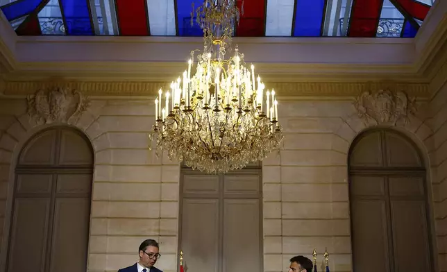 French President Emmanuel Macron, right, and Serbian President Aleksandar Vucic deliver a joint statement before a working dinner at the Elysee Palace in Paris, Monday, April 8, 2024. (Sarah Meyssonnier/Pool via AP)