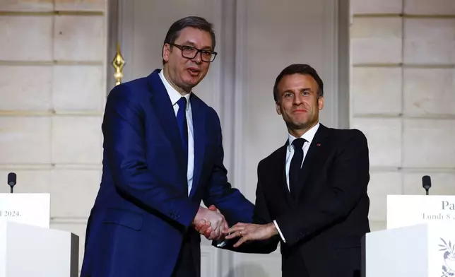 French President Emmanuel Macron, right, and Serbian President Aleksandar Vucic shake hands during a joint statement before a working dinner at the Elysee Palace in Paris, Monday, April 8, 2024. (Sarah Meyssonnier/Pool via AP)