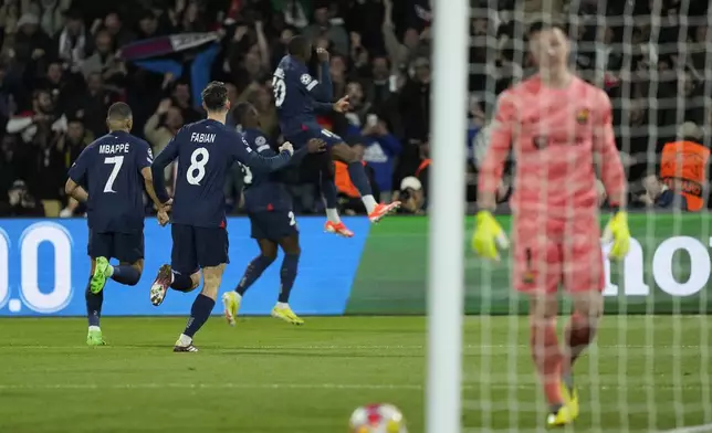 PSG's Ousmane Dembele, right, celebrates after scoring his side's opening goal during the Champions League quarterfinal first leg soccer match between Paris Saint-Germain and Barcelona at the Parc des Princes stadium in Paris, Wednesday, April 10, 2024. (AP Photo/Lewis Joly)