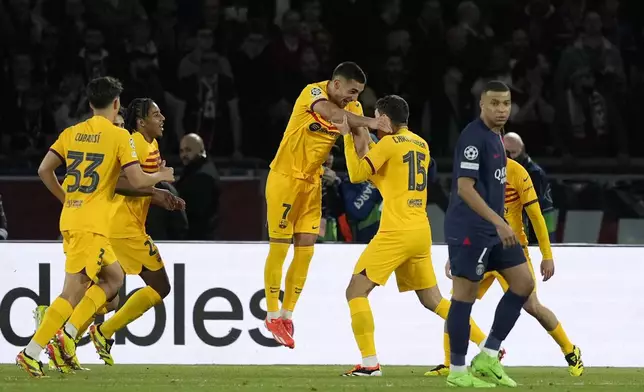 Barcelona's Andreas Christensen, center, right, celebrates after scoring his side's third goal during the Champions League quarterfinal first leg soccer match between Paris Saint-Germain and Barcelona at the Parc des Princes stadium in Paris, Wednesday, April 10, 2024. (AP Photo/Lewis Joly)