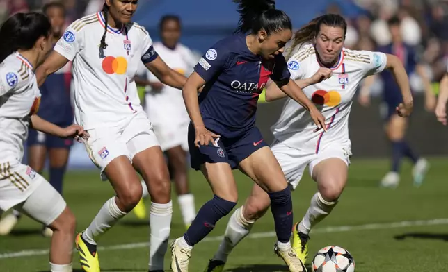 PSG's Sakina Karchaoui, center, troies to score but loses the ball to a Lyon defender during the women's Champions League semifinal, second leg, soccer match between Paris Saint-Germain and Olympique Lyonnais at Parc des Princes, in Paris, Sunday, April 28, 2024. (AP Photo/Thibault Camus)