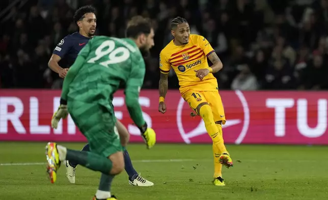Barcelona's Raphinha, right, scores his side's opening goal during the Champions League quarterfinal first leg soccer match between Paris Saint-Germain and Barcelona at the Parc des Princes stadium in Paris, Wednesday, April 10, 2024. (AP Photo/Lewis Joly)