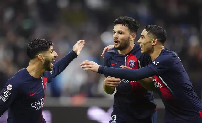 PSG's Goncalo Ramos, center, celebrates with teammate after scoring his side's second goal during the French League One soccer match between Marseille and Paris at the Velodrome stadium in Marseille, south of France, Sunday, March 31, 2024. (AP Photo/Daniel Cole)