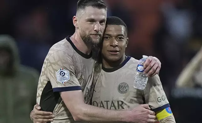 PSG's Milan Skriniar, left, hugs Kylian Mbappe after winning the French League One soccer match between Lorient and Paris Saint-Germain at the Moustoir stadium in Lorient, Brittany, western France, Wednesday, April 24, 2024. (AP Photo/Michel Euler)