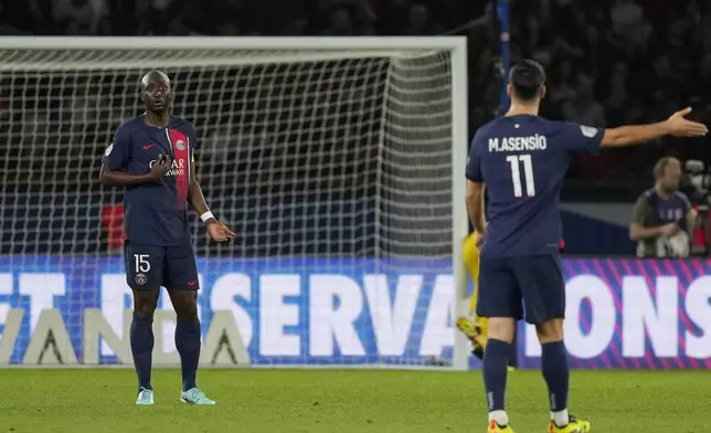 PSG's Danilo Pereira, left, and Marco Asensio react after Clermont's Habib Keita scoring his side's opening goal during the French League One soccer match between Paris Saint-Germain and Clermont at the Parc des Princes stadium in Paris, Saturday, April 6, 2024. (AP Photo/Lewis Joly)