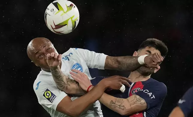 Le Havre's Andre Ayew, left, and PSG's Ethan Mbappe battle for the ball during the French League One soccer match between Paris Saint-Germain and Le Havre at the Parc des Princes in Paris, Saturday, April 27, 2024. (AP Photo/Thibault Camus)