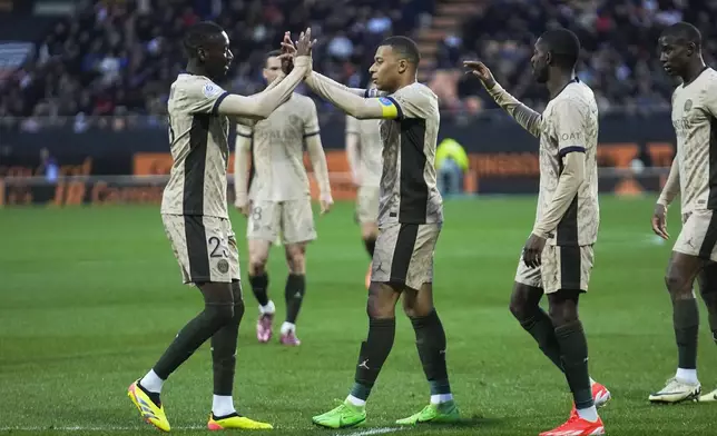 PSG players celebrate with Kylian Mbappe, center, who scored his side's fourth goal during the French League One soccer match between Lorient and Paris Saint-Germain at the Moustoir stadium in Lorient, Brittany, western France, Wednesday, April 24, 2024. (AP Photo/Michel Euler)