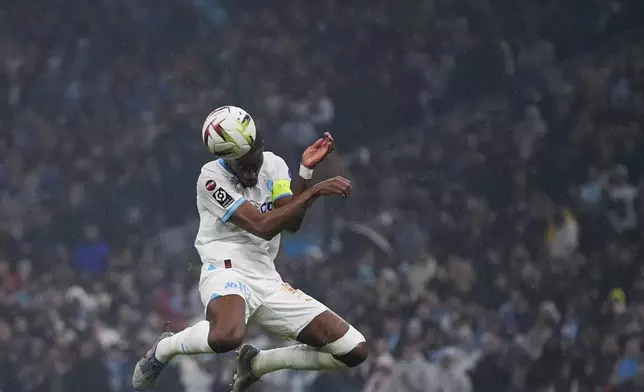 Marseille's Geoffrey Kondogbia heads the ball during the French League One soccer match between Marseille and Paris at the Velodrome stadium in Marseille, south of France, Sunday, March 31, 2024. (AP Photo/Daniel Cole)