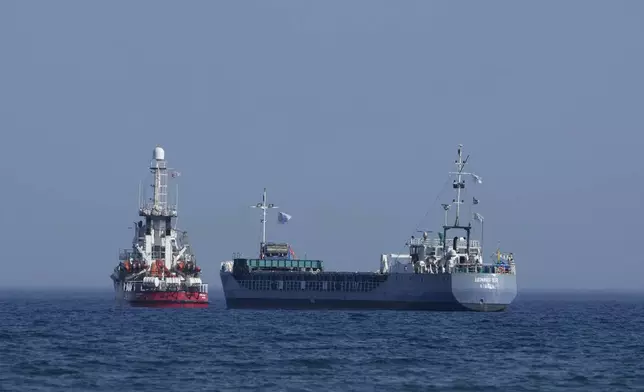 FILE - A cargo ship, right, and a ship belonging to the Open Arms aid group, are loaded with 240 tons of canned food destined for Gaza prepare to set sail outside the Cypriot port of Larnaca, Cyprus, on March 30, 2024. World Central Kitchen, the food charity founded by celebrity chef José Andrés, called a halt to its work in the Gaza Strip after an apparent Israeli strike killed seven of its workers, mostly foreigners. (AP Photo/Petros Karadjias, File)