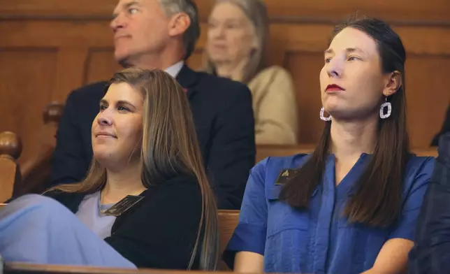 Lobbyists Brittany Jones, left, of the conservative group Kansas Family Voice, and Lucrecia Nold, right, of the Kansas Catholic Conference, watch from the Senate's west gallery as members debate overriding a proposed ban on gender-affirming care for minors, Monday, April 29, 2024, at the Statehouse in Topeka, Kan. Both of their organizations support a ban. (AP Photo/John Hanna)