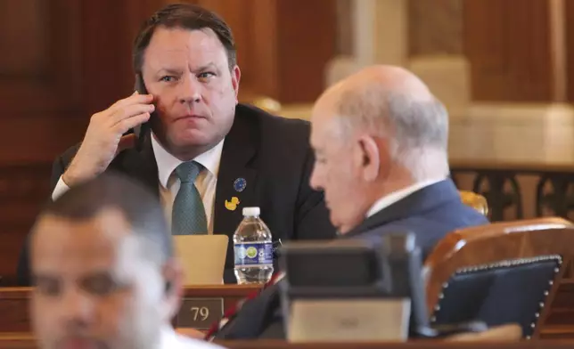 Kansas state Rep. Jesse Borjon, R-Topeka, speaks on his phone at his desk in the House chamber during a break in the House's daylong session, Monday, April 29, 2024, at the Statehouse in Topeka, Kan. Borjon has switched from voting for a proposed ban on gender-affirming care for minors to voting against overriding Democratic Gov. Laura Kelly's veto of the measure. (AP Photo/John Hanna)