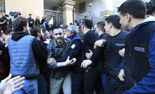 Police block protesters as they gather outside the parliament building in Tbilisi, Georgia, on Tuesday, April 16, 2024, to protest against "the Russian law" similar to a law that Russia uses to stigmatize independent news media and organizations seen as being at odds with the Kremlin. (AP Photo/Shakh Aivazov)