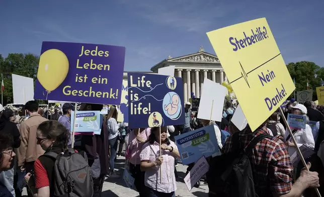 Participants in the 'March for Life' rally stand with banners reading 'Every life is a gift', 'Life is life' and 'Euthanasia no thanks' in Munich, Germany, Saturday, April 13, 2024. An independent experts commission has recommended that abortion in Germany should no longer fall under the country’s penal code and be made legal during the first 12 weeks of pregnancy. Currently, abortion is considered illegal in Germany, but not punishable if a woman undergoes mandatory counseling and a three-day wait period before she has the procedure. (Uwe Lein/dpa via AP)