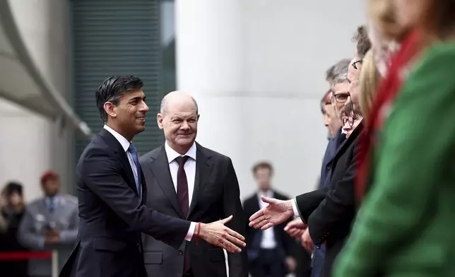 German Chancellor Olaf Scholz, second left, and Britain's Prime Minister Rishi Sunak, left, greet delegation members during an official welcome ceremony at the Chancellery in Berlin, Wednesday April 24, 2024. (Henry Nicholls/Pool via AP)