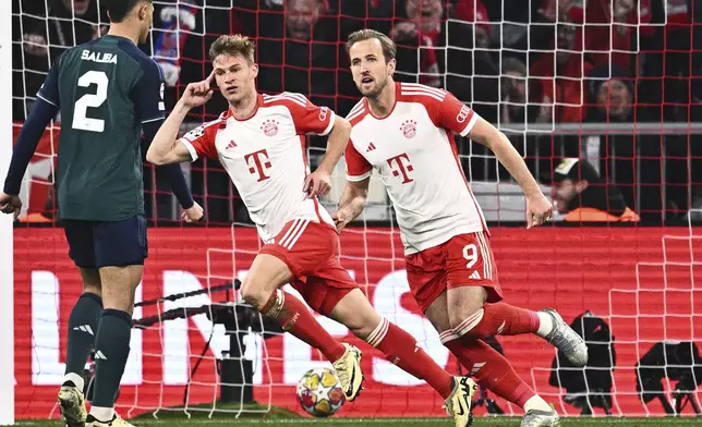 Bayern's Joshua Kimmich, center, and Harry Kane (9) celebrate after Kimmich scored during the Champions League quarter final second leg soccer match between Bayern Munich and Arsenal at the Allianz Arena in Munich, Germany, Wednesday, April 17, 2024. (Tom Weller/dpa via AP)