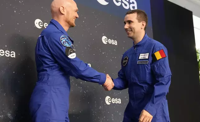 Astronauts crew leader Alexander Geerst, left, hands over the badge to Raphael Liegeois of Belgium at the candidates of the Class of 2022 graduation ceremony at the European Astronaut Centre in Cologne, Germany, Monday, April 22, 2024. ESA astronaut candidates Sophie Adenot of France, Pablo Alvarez Fernandez of Spain, Rosemary Coogan of Britain, Raphael Liegeois of Belgium and Marco Sieber of Switzerland took up duty at the European Astronaut Centre one year ago to be trained to the highest level of standards as specified by the International Space Station partners. Also concluding a year of astronaut basic training is Australian astronaut candidate Katherine Bennell-Pegg, who has trained alongside ESA's candidates. (AP Photo/Martin Meissner)