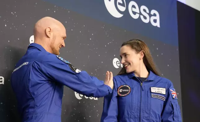 Astronauts crew leader Alexander Geerst, left, hands over the badge to Rosemary Coogan of Britain at the candidates of the Class of 2022 graduation ceremony at the European Astronaut Centre in Cologne, Germany, Monday, April 22, 2024. ESA astronaut candidates Sophie Adenot of France, Pablo Alvarez Fernandez of Spain, Rosemary Coogan of Britain, Raphael Liegeois of Belgium and Marco Sieber of Switzerland took up duty at the European Astronaut Centre one year ago to be trained to the highest level of standards as specified by the International Space Station partners. Also concluding a year of astronaut basic training is Australian astronaut candidate Katherine Bennell-Pegg, who has trained alongside ESA's candidates. (AP Photo/Martin Meissner)
