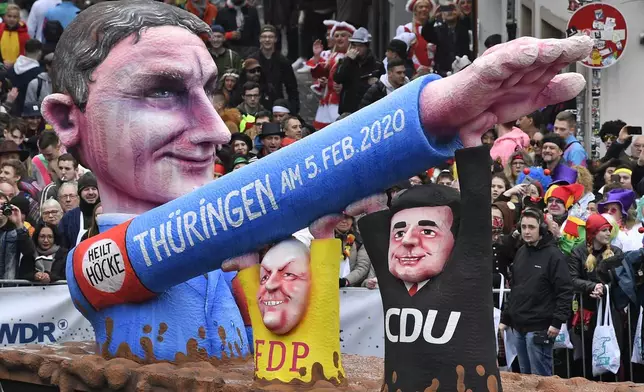 FILE - A carnival float, depicting far-right AfD politician Bjoern Hoecke, whose arm is raised by CDU and FDP politicians at the Thuringia elections, takes part the traditional carnival parade in Duesseldorf, Germany, Monday, Feb. 24, 2020. One of the most prominent figures in the far-right Alternative for Germany party is going on trial Thursday on charges of twice using a Nazi slogan, months before a regional election in which he is running to become his state’s governor. Bjoern Hoecke is the leader of the regional branch of Alternative for Germany, or AfD, in the eastern state of Thuringia. (AP Photo/Martin Meissner, File)