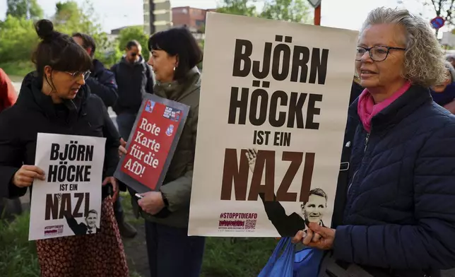 Protestors hold banners reading 'Bjoern Hoecke is a nazi' outside the state court in Halle, Germany, Thursday, April 18, 2024. Bjoern Hoecke, goes on trial at the state court in Halle on charges related to his alleged use in a 2021 speech of a slogan used by the Nazis' SA stormtroopers. (Fabrizio Bensch/Pool via AP)