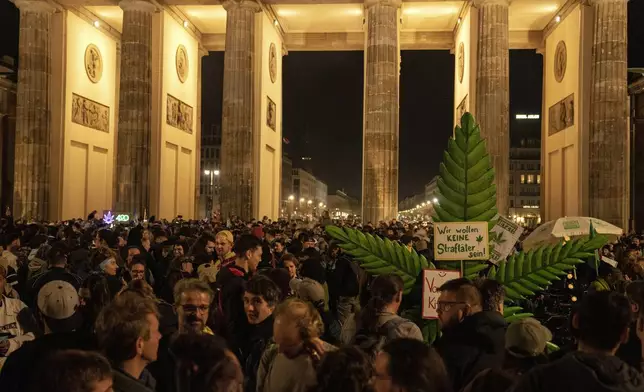 People smoke marijuana in front of the Brandenburg Gate during the 'Smoke-In' event in Berlin, Germany, Monday, April 1, 2024. Starting 1 April, Germany has legalised cannabis for personal use. As per the new law, Adults aged 18 and over will be allowed to carry up to 25 grams of cannabis for their own consumption. (AP Photo/Ebrahim Noroozi)