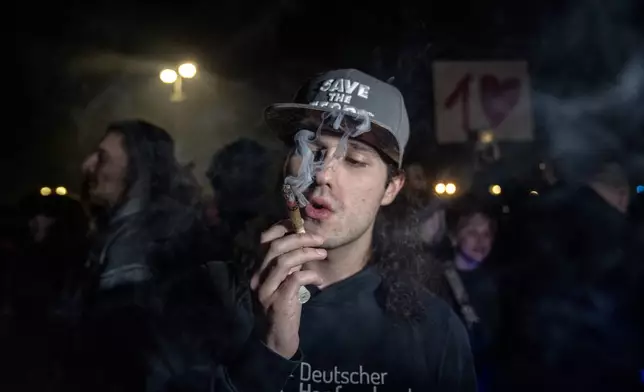 A man takes a puff from a marijuana cigarette in front of the Brandenburg Gate during the 'Smoke-In' event in Berlin, Germany, Monday, April 1, 2024. Starting 1 April, Germany has legalised cannabis for personal use. As per the new law, Adults aged 18 and over will be allowed to carry up to 25 grams of cannabis for their own consumption. (AP Photo/Ebrahim Noroozi)