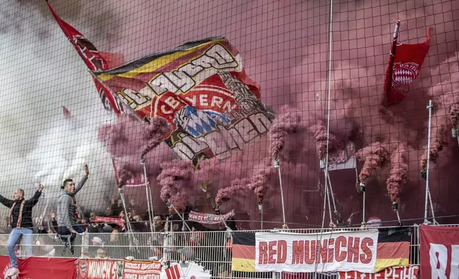 Bayern Munich fans set off smoke bombs during the German Bundesliga soccer match between FC Union Berlin and Bayern Munich at the An der Alten Forsterei stadium in Berlin, Germany, Saturday, April 20, 2024. (Andreas Gora/dpa via AP)