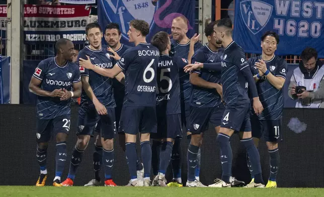 Bochum's scorer Philipp Hofmann, sixth from left, and his teammates celebrate their side's second goal during the Bundesliga soccer match between VfL Bochum and SV Darmstadt 98 in Bochum, Germany, Sunday, March 31, 2024. (David Inderlied/dpa via AP)