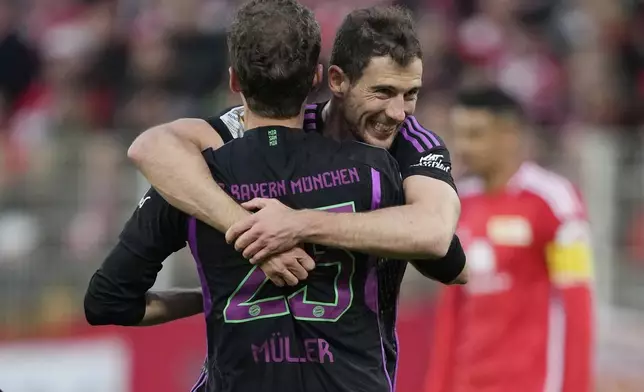 Bayern's Thomas Mueller celebrates with his teammate Leon Goretzka after scoring his side's fifth goal during the German Bundesliga soccer match between FC Union Berlin and Bayern Munich at the An der Alten Forsterei stadium in Berlin, Germany, Saturday, April 20, 2024. (AP Photo/Ebrahim Noroozi)