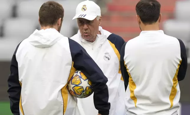 Real Madrid's head coach Carlo Ancelotti, center, talks to his assistant coaches during a training session in Munich, Germany, Monday, April 29, 2024, ahead of the Champions League semi final first leg soccer match between FC Bayern Munich and Real Madrid. (AP Photo/Matthias Schrader)