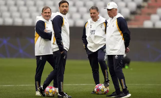 Real Madrid's head coach Carlo Ancelotti, right, waits besides his son, assistant coach Davide Ancelotti, second left, for a training session in Munich, Germany, Monday, April 29, 2024, ahead of the Champions League semi final first leg soccer match between FC Bayern Munich and Real Madrid. (AP Photo/Matthias Schrader)