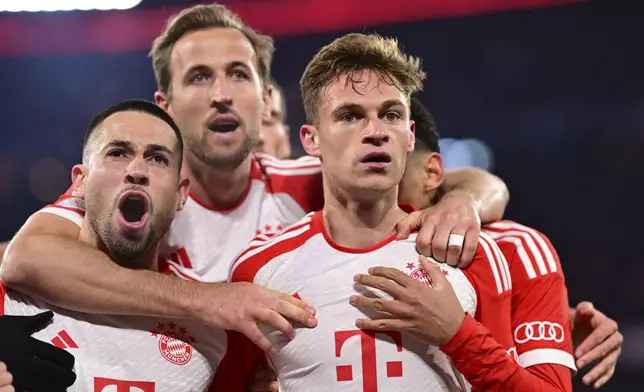 Bayern's Joshua Kimmich, right, celebrates with teammates after scoring his side's opening goal during the Champions League quarter final second leg soccer match between Bayern Munich and Arsenal at the Allianz Arena in Munich, Germany, Wednesday, April 17, 2024. (AP Photo/Christian Bruna)