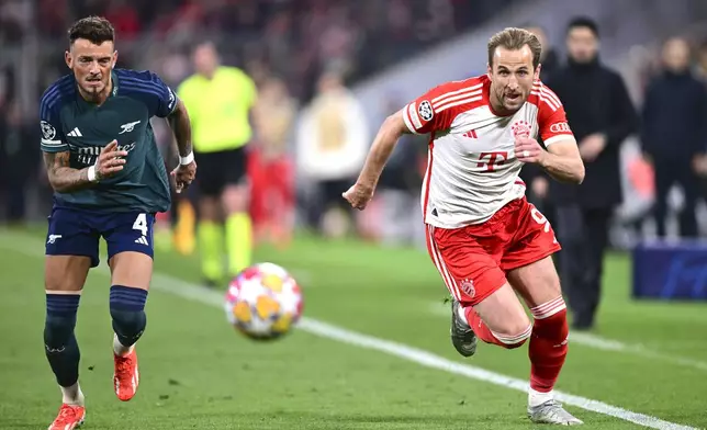 Arsenal's Ben White, left, and Bayern's Harry Kane run for the ball during the Champions League quarter final second leg soccer match between Bayern Munich and Arsenal at the Allianz Arena in Munich, Germany, Wednesday, April 17, 2024. (AP Photo/Christian Bruna)