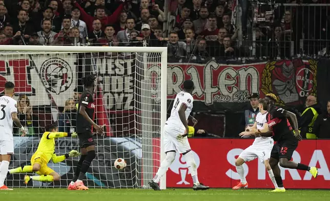 Leverkusen's Victor Boniface, right, scores his side's second goal during the Europa League quarterfinals first leg soccer match between Bayer 04 Leverkusen and West Ham United at the BayArena in Leverkusen, Germany, Thursday, April 11, 2024. (AP Photo/Martin Meissner)