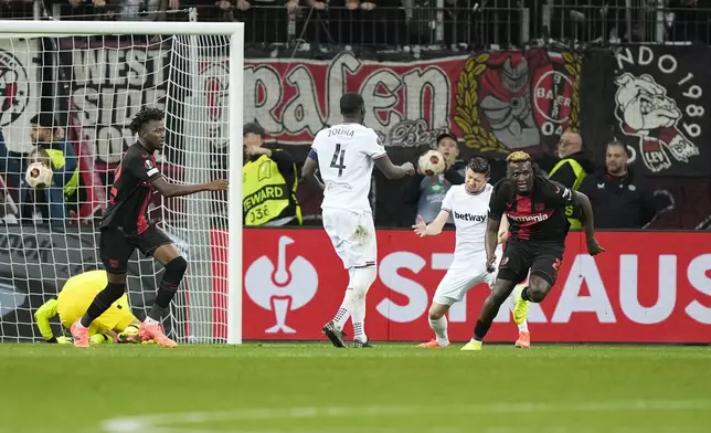 Leverkusen's Victor Boniface, right, celebrates after scoring his side's second goal during the Europa League quarterfinals first leg soccer match between Bayer 04 Leverkusen and West Ham United at the BayArena in Leverkusen, Germany, Thursday, April 11, 2024. (AP Photo/Martin Meissner)