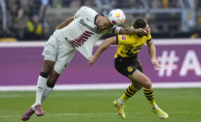 FILE - Leverkusen's Jonathan Tah, left, and Dortmund's Niclas Fuellkrug, right, go for a header during the German Bundesliga soccer match between Borussia Dortmund and Bayer Leverkusen in Dortmund, Germany, Sunday, April 21, 2024. Tah won the Bundesliga title already, and has also the chance to win the German Cup and the Europa League this season with Leverkusen. Tah is also defender for Germany's national team. (AP Photo/Martin Meissner)