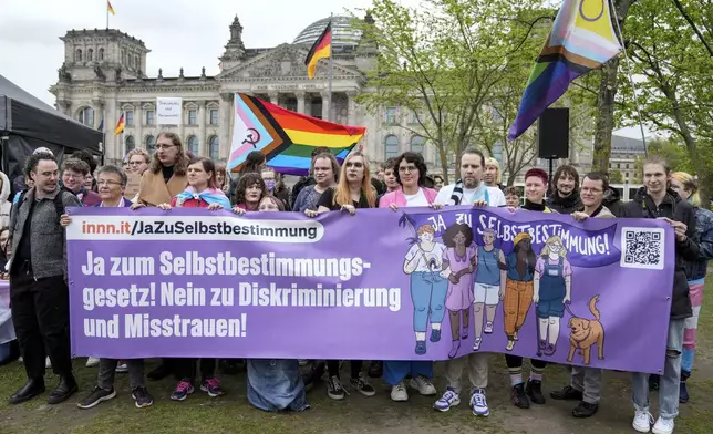 Demonstrators protest demanding a law to protect the rights of the transgender community outside of the parliament Bundestag building in Berlin, Friday, Apri 12, 2024. German lawmakers on Friday approved legislation that will make it easier for transgender, intersex and nonbinary people to change their name and gender in official records. (AP Photo/Ebrahim Noroozi)