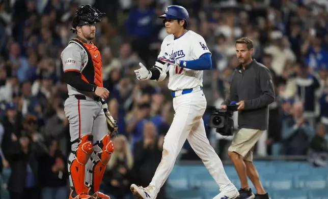 Los Angeles Dodgers designated hitter Shohei Ohtani celebrates after hitting a home run during the seventh inning of a baseball game against the San Francisco Giants in Los Angeles, Wednesday, April 3, 2024. (AP Photo/Ashley Landis)