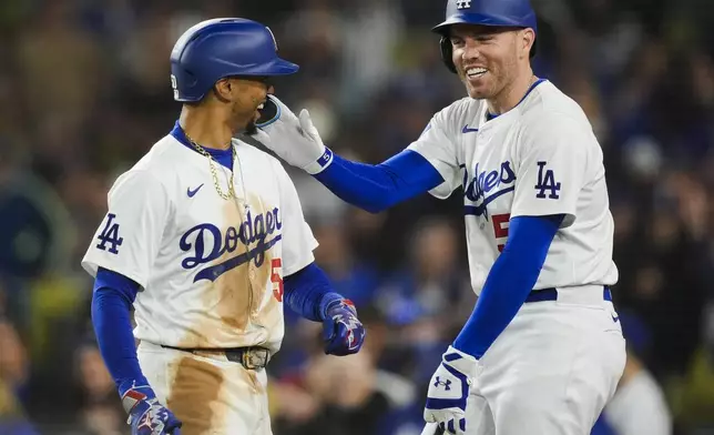 Los Angeles Dodgers' Mookie Betts, left, celebrates his home run against the San Francisco Giants with Freddie Freeman during the third inning of a baseball game Tuesday, April 2, 2024, in Los Angeles. (AP Photo/Ryan Sun)