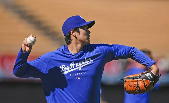 Los Angeles Dodgers designated hitter Shohei Ohtani warms up for the team's baseball game against the San Francisco Giants, Tuesday, April 2, 2024, in Los Angeles. (AP Photo/Ryan Sun)