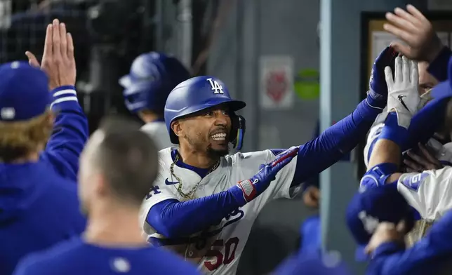 Los Angeles Dodgers' Mookie Betts is congratulated for a home run against the San Francisco Giants during the third inning of a baseball game Tuesday, April 2, 2024, in Los Angeles. (AP Photo/Ryan Sun)