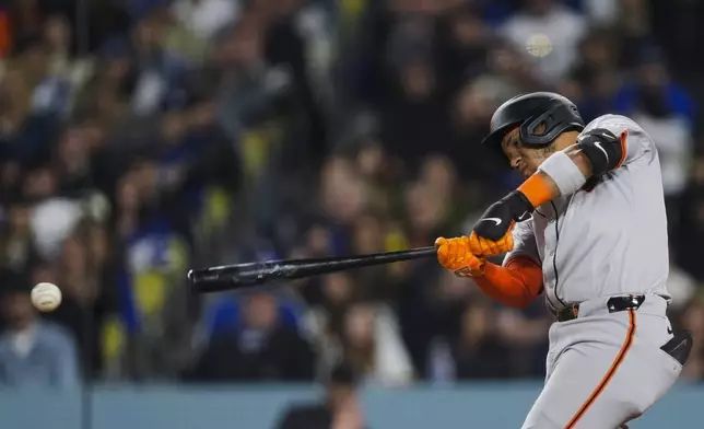 San Francisco Giants' Thairo Estrada hits a single against the Los Angeles Dodgers during the sixth inning of a baseball game Tuesday, April 2, 2024, in Los Angeles. Michael Conforto scored. (AP Photo/Ryan Sun)