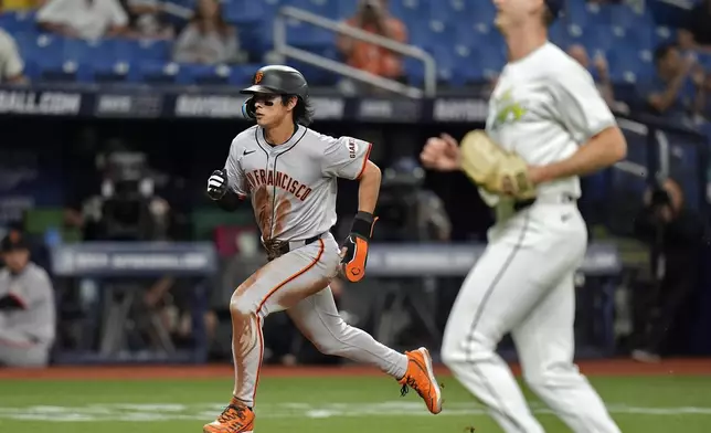 San Francisco Giants' Jung Hoo Lee, left, scores in front of Tampa Bay Rays pitcher Jacob Waguespack on a passed ball by catcher Ben Rortvedt during the third inning of a baseball game Friday, April 12, 2024, in St. Petersburg, Fla. (AP Photo/Chris O'Meara)