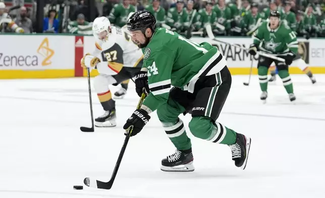 Dallas Stars left wing Jamie Benn (14) controls the puck on an attack just before shooting and scoring as Vegas Golden Knights' Shea Theodore (27) looks on in the first period in Game 1 of an NHL hockey Stanley Cup first-round playoff series in Dallas, Monday, April 22, 2024. (AP Photo/Tony Gutierrez)