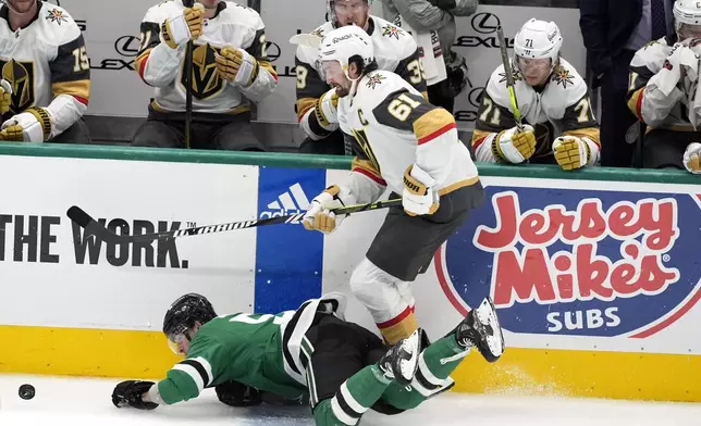 Dallas Stars center Wyatt Johnston, left, falls to the ice attempting to control the puck under pressure from Vegas Golden Knights right wing Mark Stone (61) in the third period in Game 1 of an NHL hockey Stanley Cup first-round playoff series in Dallas, Monday, April 22, 2024. (AP Photo/Tony Gutierrez)