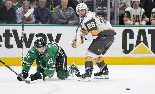Dallas Stars left wing Jason Robertson (21) is tripped up by Vegas Golden Knights left wing William Carrier (28) during Game 2 of an NHL hockey Stanley Cup first-round playoff series in Dallas, Wednesday, April 24, 2024. (AP Photo/Tony Gutierrez)